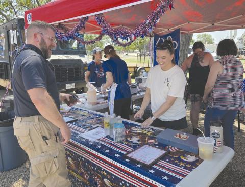 LUNCHTIME ON THE FOURTH Locals who turned out for the Fourth of July celebration at Leatherman Park got to enjoy lots of activities, contests, fireworks, and much more. And whenever they needed some fuel to keep themselves going, there were plenty of food trucks on hand to serve up lunch, snacks, or a cold drink. Pictured picking up lunch from a booth set up by the Museum of the Plains is Jeff Mincy, at left, and Yancy Judice.
