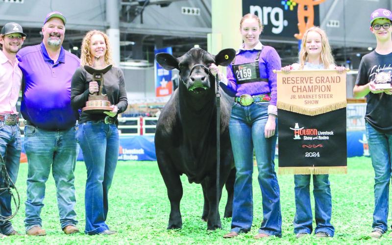 HOUSTON STOCK SHOW RESERVE GRAND CHAMP Maddie Schickedanz showed the reserve grand steer at the Houston Livestock Show and Rodeo March ??. She won the honor with TJ. Pictured from left are coach Kyle Tarter, Jason Schickedanz, Amber Schickedanz, TJ, Maddie, Sydney Schickedanz and Jake Schickedanz, all of Perryton.