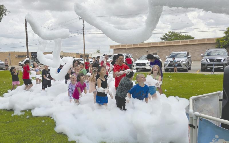 For the last session of Perry Memorial Library’s annual Summer Reading program, kids got to celebrate with a special foam party on last Tuesday afternoon. Kids broke out their swimsuits, sunglasses, and flipflops to dance and play in torrents of biodegradable, hypo-allergenic, soap-like foam shot out of a giant foam cannon.