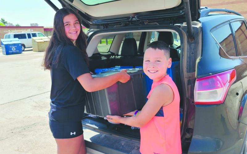 School may be out for the summer, but Snack Pak 4 Kids is still working hard to make sure kids get delicious and nutritious snacks. The organization is distributing snack bags every Thursday through the end of July from 11:30 a.m. to 12:30 p.m. at Stark Park, Leatherman Park, and Murphy Park. Pictured loading up the family car to deliver snacks are, from left, upcoming freshman Kynzie Lynch and Darrell Lynch, age 9.