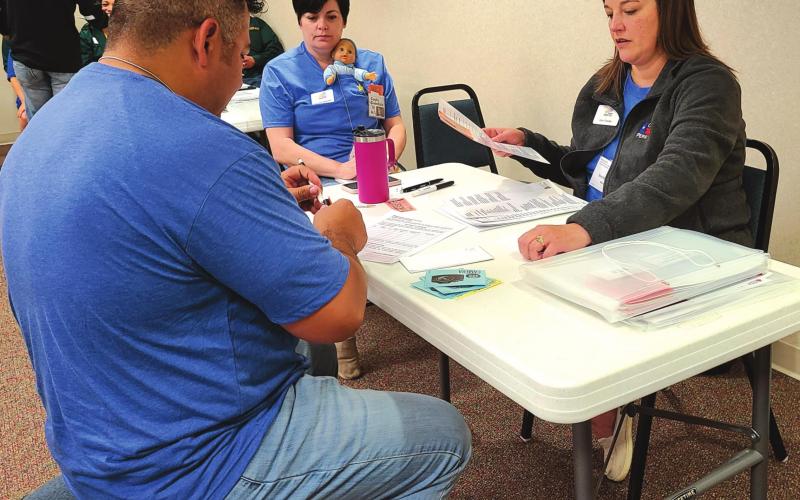LEARNING ABOUT POVERTY Members of Leadership Perryton XIX participated in a Community Action Poverty Simulation on Friday, learning about some of the realities and challenges faced by low-income families. Participants took on the roles of families trying to provide basic necessities and shelter while volunteers portrayed community organizations, banks, employers, and more. Pictured are, from left, Mac Hernandez, Angela Petersen (with “baby”), and Kim Fowler, portraying a social services agency.