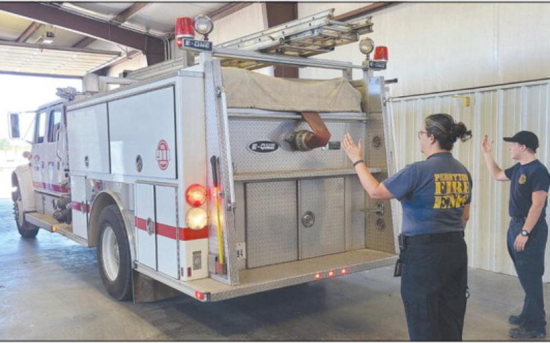 The Perryton Fire Department made their official move late last week from the Ochiltree County Expo Center to their new location at the old Stoehr Wire Rope building at 602 E. Brillhart. Pictured are, from left, paramedic Emily Flores and firefighter Josiah Raab helping guide one of the fire department’s trucks into its new home.