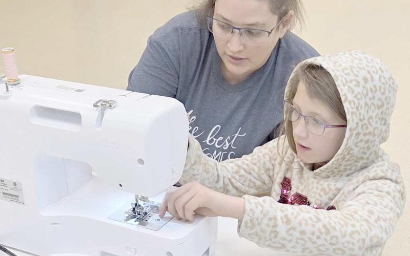 The Learn to Sew/Fashion Show project at the Ochiltree County 4-H Club is in full swing, with students learning the basics of sewing, along with more advanced techniques. Pictured are Jasmine Hunt, left, with Kayanna Duran, age 10, a first-year sewer, learning how to thread a sewing machine.