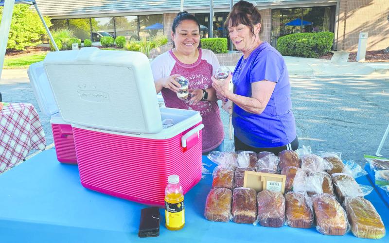 Local residents have been turning out for the Ochiltree County Farmers Market every Saturday for their pick of farm-fresh vegetables, homemade bread and pastries, handmade crafts and quilts, and much more. Pictured are, from left, Rene Schwalk and Penny Clark picking out some new treats to enjoy. The last day of the market will be this Saturday, Sept. 14.