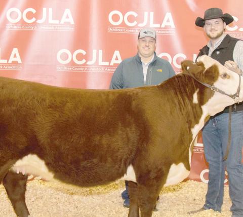 GRAND CHAMPION HEIFER— At the Ochiltree County Junior Livestock Show and Sale on Jan. 19-20, Evan Born took home the award for Grand Champion Heifer. His animal was purchased by FirstBank Southwest. Pictured are, from left, Darren Chisum and Evan Born. ( Photo credit: Tessa Powell)
