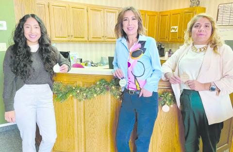 The City of Perryton has set a Giving Garland this year instead of the traditional Giving Tree in City Hall to assist local citizens who have difficulty paying their winter heating bills. Anyone can make anonymous donations to help pay utility bills for area seniors. Pictured with the garland are, from left, city employees Sandra Sosa, Laura Rivera, and Patricia Martinez.