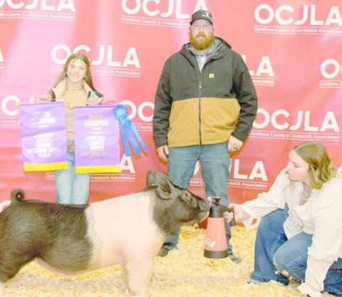 GRAND CHAMPION SWINE— At the Ochiltree County Junior Livestock Show and Sale, Hallie Lopez took home the award for Grand Champion Swine. Her animal was purchased by Wright Water Well Services and Allen Irrigation. Pictured are, from left, Hallie Lopez, Steven Wright, and Raylee Murry. (Photo Credit: Tessa Powell)