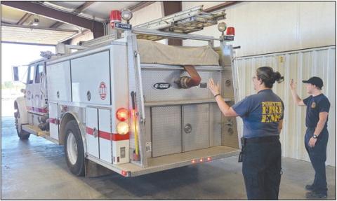 The Perryton Fire Department made their official move late last week from the Ochiltree County Expo Center to their new location at the old Stoehr Wire Rope building at 602 E. Brillhart. Pictured are, from left, paramedic Emily Flores and firefighter Josiah Raab helping guide one of the fire department’s trucks into its new home.