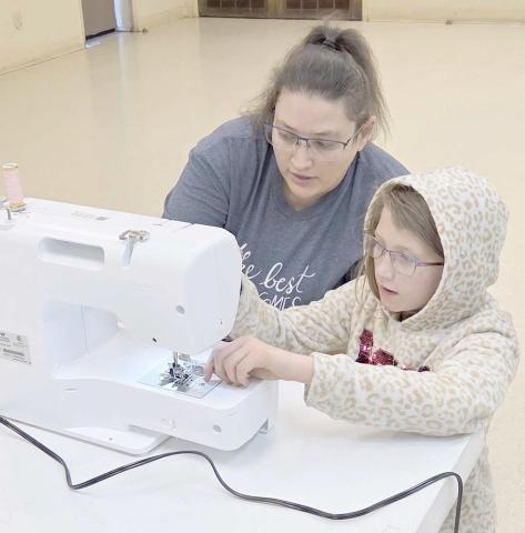 The Learn to Sew/Fashion Show project at the Ochiltree County 4-H Club is in full swing, with students learning the basics of sewing, along with more advanced techniques. Pictured are Jasmine Hunt, left, with Kayanna Duran, age 10, a first-year sewer, learning how to thread a sewing machine.