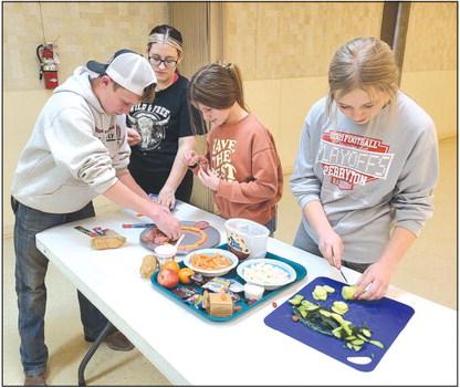 Members in Ochiltree County 4H’s Alamo Club tested their culinary skills last week on Monday as they worked to assemble snack boards, featuring meat, cheese, fruits, crackers, and candies. Pictured are, from left, Kyle Oquin, Emmalyn Overton, Hallie Lopez, and Emmalee Lopez.