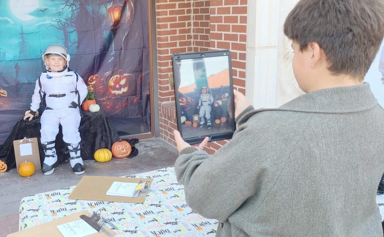 LIFTOFF FOR HALLOWEEN— Perryton residents turned out downtown on Oct. 15 for sales, entertainment, and fun snacks during the Perryton Ochiltree Chamber of Commerce’s annual Moonlight Madness event. Lots of kids showed up to enter the Chamber’s annual costume contest. Pictured are, from left, young astronaut Mason McDaniels, age 6, and Drake Vasquez, 12, taking photos of costume entrants for the Chamber.