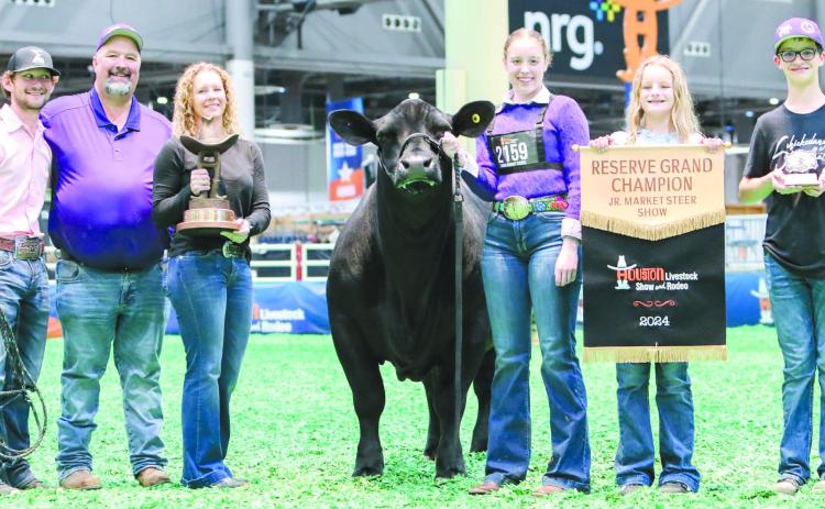 HOUSTON STOCK SHOW RESERVE GRAND CHAMP Maddie Schickedanz showed the reserve grand steer at the Houston Livestock Show and Rodeo March ??. She won the honor with TJ. Pictured from left are coach Kyle Tarter, Jason Schickedanz, Amber Schickedanz, TJ, Maddie, Sydney Schickedanz and Jake Schickedanz, all of Perryton.