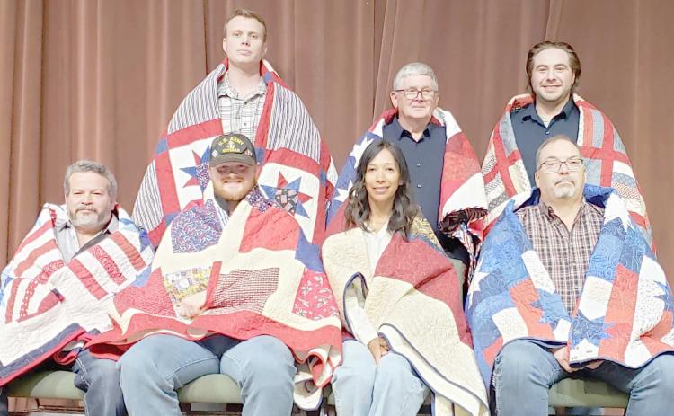 QUILTS OF VALOR PRESENTATION— The Friendship Quilt Guild presented 14 Quilts of Valor to area veterans on Oct. 17. The first seven recipients were, front row from left, Carmelo Tarango, Erik Evans, Nadine Barton and Erick Kear; and back row, Luke Butler, Gary Noggle and Kenneth Hodo.