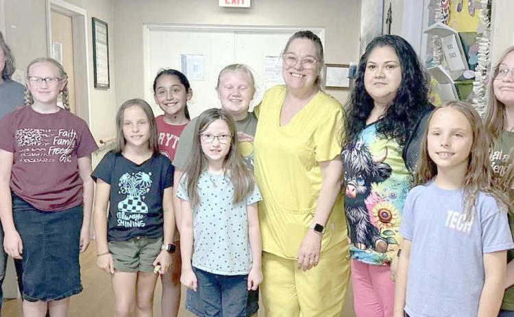 4-H MEMBERS SEW PILLOWCASES FOR CAPSTONE RESIDENTS— Ochiltree County 4-H members in the fashion/beginner sewing class learned basic sewing skills by hand and on the sewing machine. They constructed 19 pillowcases for residents at Capstone Healthcare of Perryton as a final project. Pictured are, from left, senior leader Rylan Oquin, Hannah Young, Izzy Heck, Madison Knox, Isabella Gonzalez, Madison Knox, Rebekah Young, Capstone LVN Melissa Windham, CNA Gloria Gonzales, Gabby Heck and Kylee Knox.