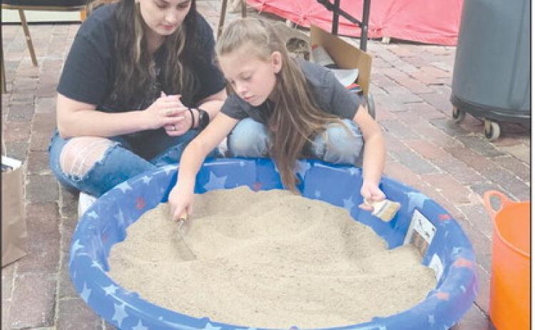 Family Archaeology Day, held last Saturday at the Museum of the Plains, gave kids and adults lots of ways to learn about the science of archaeology, including carefully sifting through an artificial archaeology dig to find artifacts, fossils, unusual stones, and more. Attendees at the event also got to enjoy art, crafts, games, and much more. Pictured looking for artifacts in the artificial archaeology dig are Lauren Goza and Juliza Thomas, age 7.