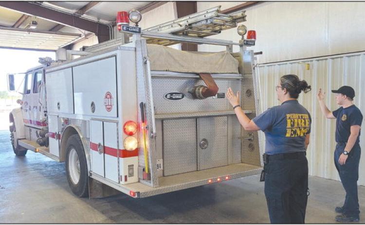 The Perryton Fire Department made their official move late last week from the Ochiltree County Expo Center to their new location at the old Stoehr Wire Rope building at 602 E. Brillhart. Pictured are, from left, paramedic Emily Flores and firefighter Josiah Raab helping guide one of the fire department’s trucks into its new home.