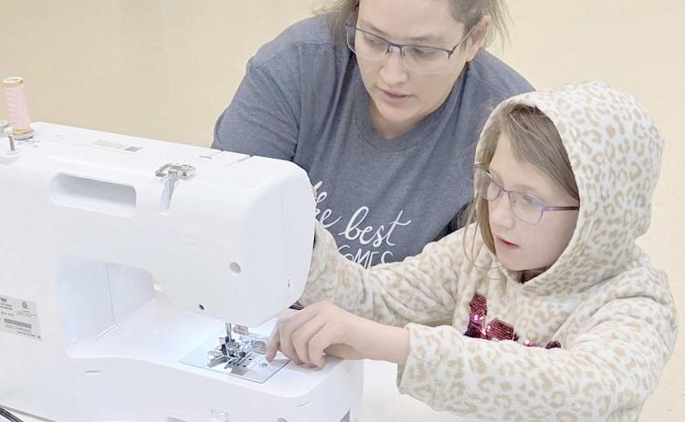 The Learn to Sew/Fashion Show project at the Ochiltree County 4-H Club is in full swing, with students learning the basics of sewing, along with more advanced techniques. Pictured are Jasmine Hunt, left, with Kayanna Duran, age 10, a first-year sewer, learning how to thread a sewing machine.